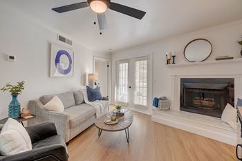 A living room with a grey couch, a coffee table, and a fireplace.